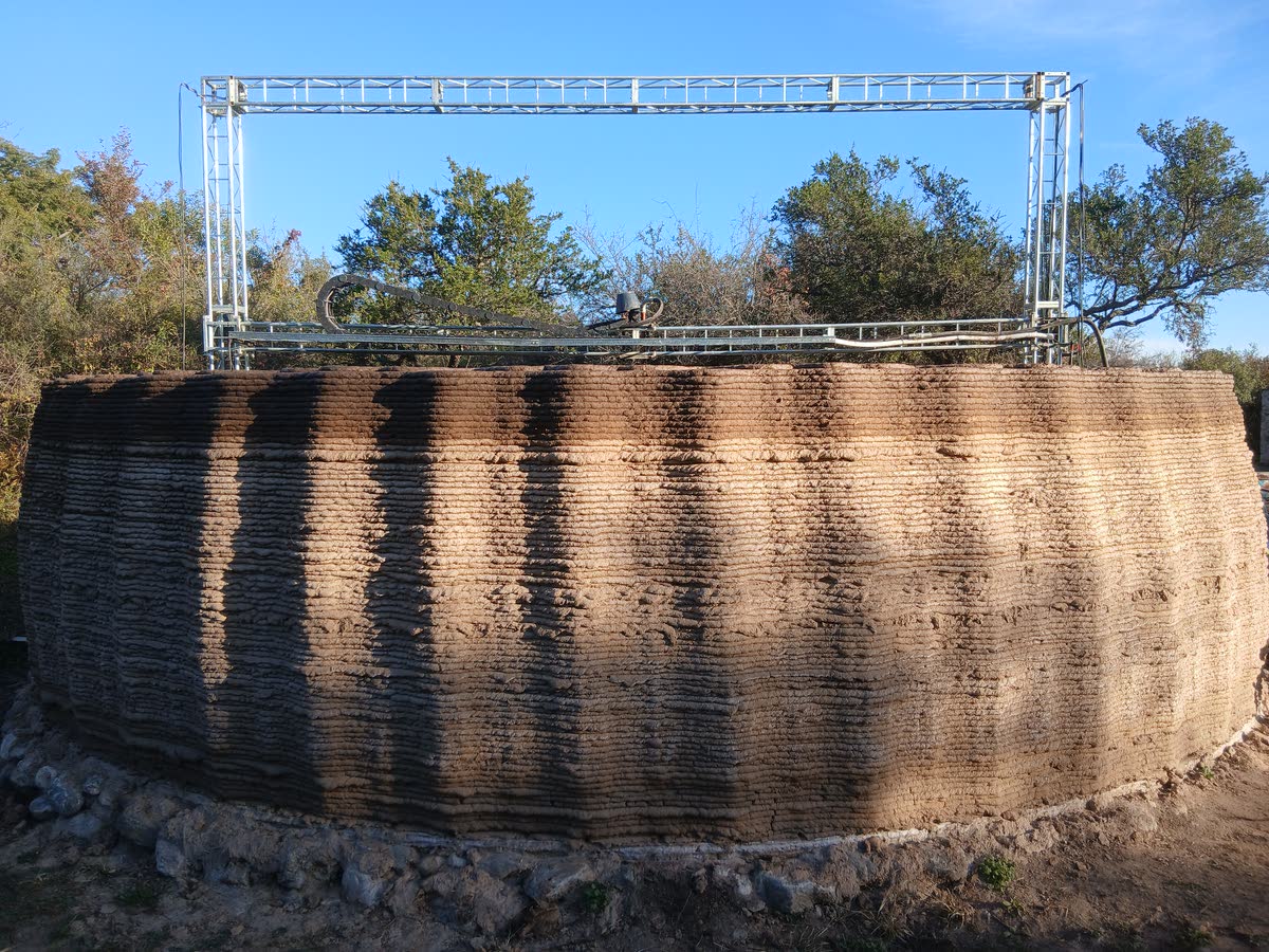 El muro impreso alcanzando su altura final, con el pórtico de la impresora encima